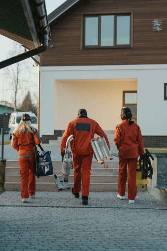 Agents de nettoyage en combinaison se rendant sur un chantier de maison neuve