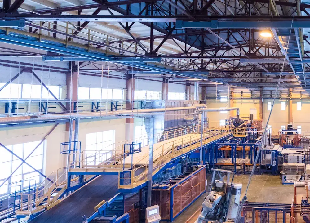 Vue d’un atelier industriel lumineux avec des passerelles et des machines en activité.